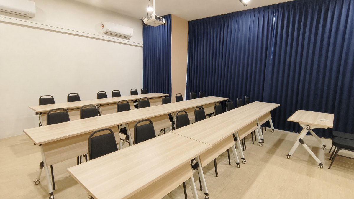 Warm, fully prepared VECTOR Learning Studio training room with tables, chairs and ceiling projector